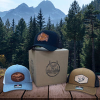 Rustic Pines hats sitting on a platform with a mountain view in the background.